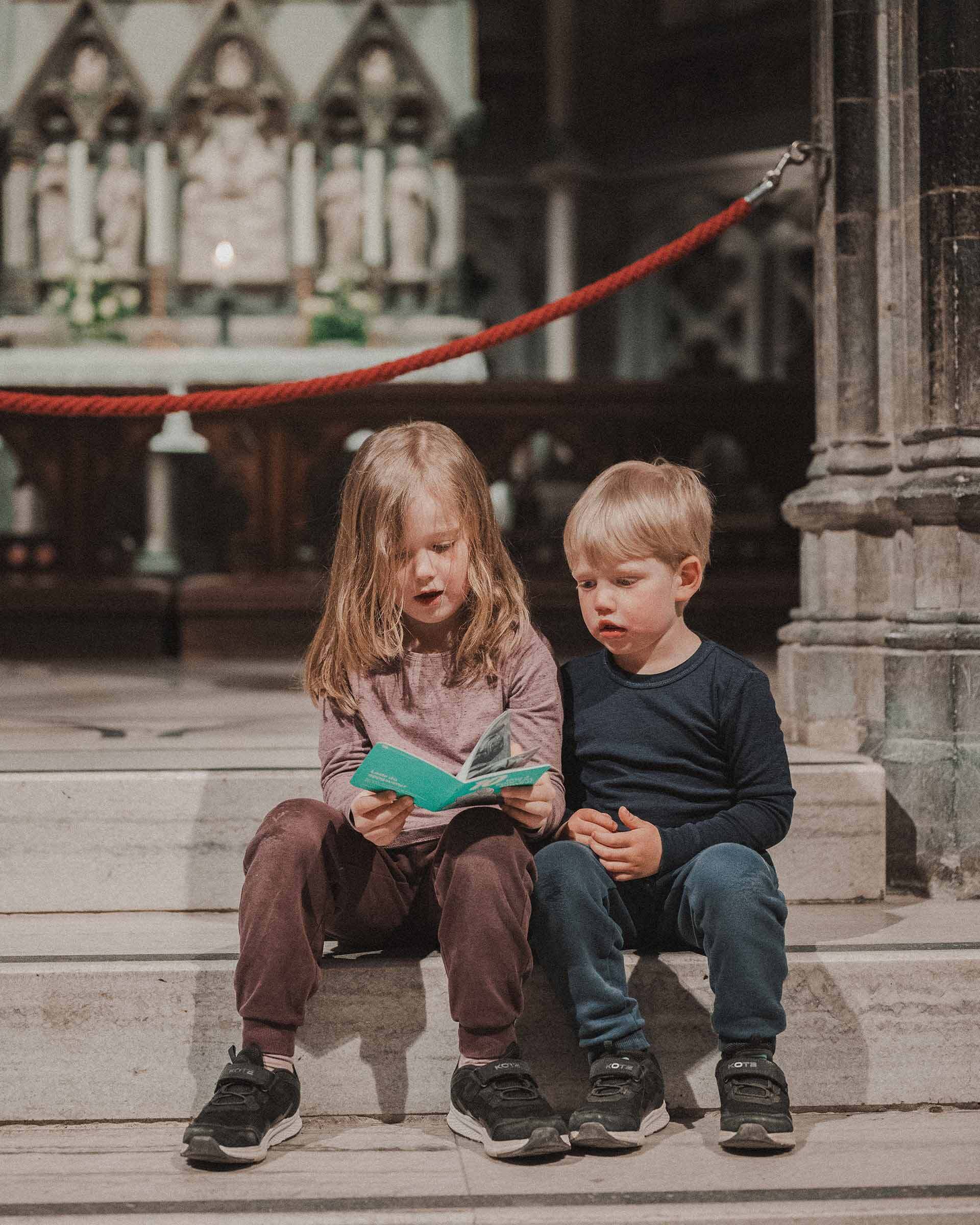 To barn ser i oppgavehefte i Nidarosdomen. Foto To barn ser i oppgavehefte i Nidarosdomen. Foto