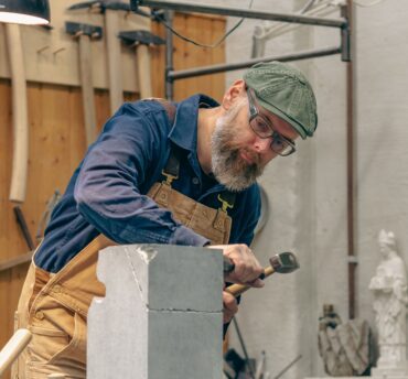 En steinhugger hugger på en stein.