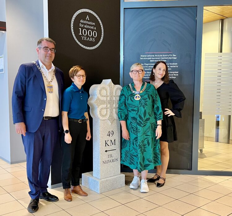 To ordførere og to damer står ved en milestein To ordførere og to damer står ved en milestein