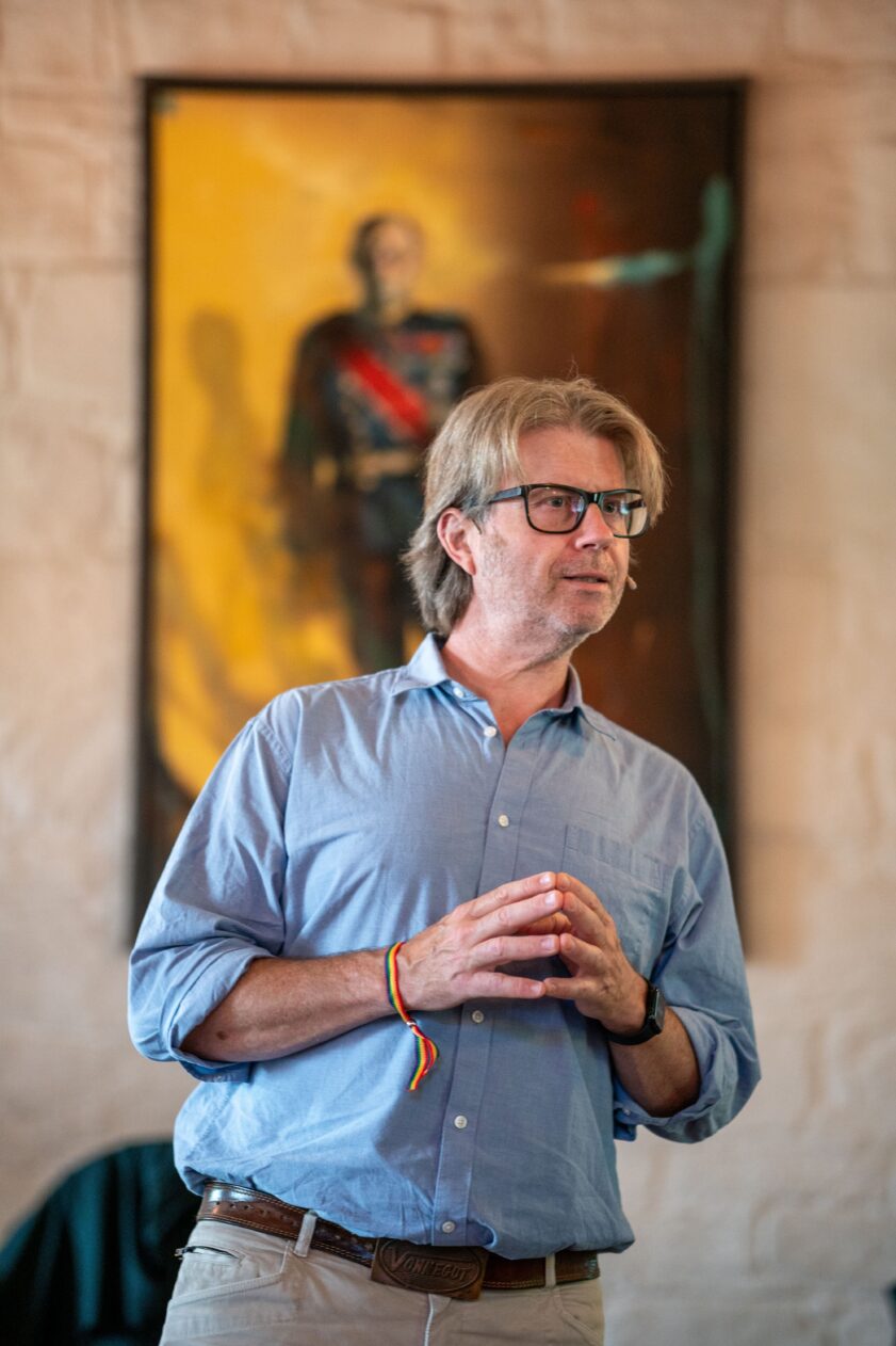 Are Sende Osen står og prater, med et portrett av kong Harald i bakgrunnen. Are Sende Osen står og prater, med et portrett av kong Harald i bakgrunnen.