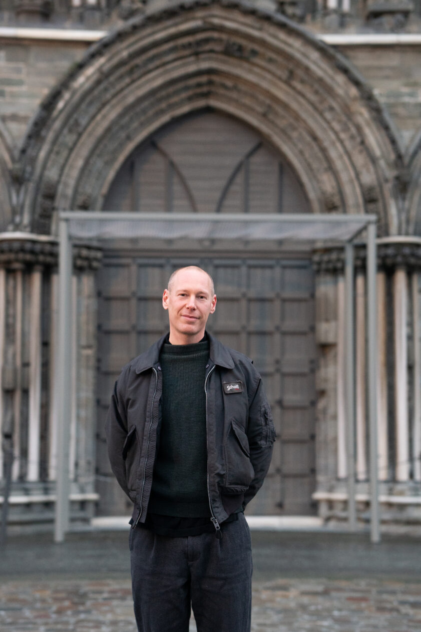 Portrett av Fredrik Tydén foran Nidarosdomens gamle dører. Foto
